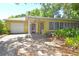Cozy home with a brick driveway, attached garage, and vibrant landscaping, inviting entryway at 1125 N Mc Donald St, Mount Dora, FL 32757