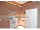 Bright kitchen with wood ceiling beam, cabinets, and white appliances at 1125 N Mc Donald St, Mount Dora, FL 32757