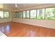 Light-filled sunroom with hardwood floors, and multiple windows overlooking the landscape at 1125 N Mc Donald St, Mount Dora, FL 32757