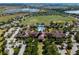 Aerial view showcases the community clubhouse, pool, tennis courts, and surrounding residences and green space at 115 Crescent Moon Dr, Groveland, FL 34736