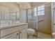 Bright bathroom showcasing a vanity, toilet, and glass-enclosed tiled shower at 115 Crescent Moon Dr, Groveland, FL 34736