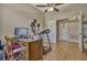 Bedroom features a desk, chair, ceiling fan, and a doorway to another room at 115 Crescent Moon Dr, Groveland, FL 34736