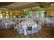 Elegant event hall with tables decorated with white tablecloths, silver chairs, and floral centerpieces at 115 Crescent Moon Dr, Groveland, FL 34736