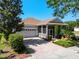 Charming single-story home with a screened porch, two-car garage, and a well-maintained brick driveway at 115 Crescent Moon Dr, Groveland, FL 34736