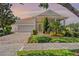Charming single-story home with a screened porch, two-car garage, and lush landscaping at 115 Crescent Moon Dr, Groveland, FL 34736