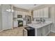 Bright kitchen equipped with white cabinetry, stainless appliances, and a breakfast bar perfect for casual dining at 115 Crescent Moon Dr, Groveland, FL 34736