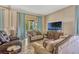 Comfortable living room with neutral tones, tile flooring, and a sliding glass door leading to the outdoors at 115 Crescent Moon Dr, Groveland, FL 34736