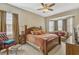 Cozy main bedroom suite features carpet, a bay window, a large comfortable bed and relaxing sitting area at 115 Crescent Moon Dr, Groveland, FL 34736