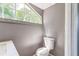Bright bathroom featuring an attractive window allowing natural light, and a modern toilet at 1234 Parker Ave, Deltona, FL 32725