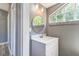 Bright bathroom featuring modern vanity with sink, round mirror and window letting in natural light at 1234 Parker Ave, Deltona, FL 32725