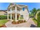 Exterior view of two-story home with covered patio, balcony, and paved driveway at 1341 Lyndale Blvd, Winter Park, FL 32789
