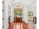 Bright foyer with hardwood floors, a modern chandelier, and a wooden front door at 1341 Lyndale Blvd, Winter Park, FL 32789
