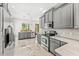 Charming kitchen with gray cabinets, stainless steel appliances, marble countertops, and hanging pendant lights at 1341 Lyndale Blvd, Winter Park, FL 32789