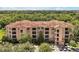 Beautiful Tuscan-style condo building with a red tile roof and lush landscaping at 1375 Tuscana Ln # 1408, Davenport, FL 33896