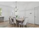 Elegant dining room featuring a modern chandelier, light wood table, and ample seating for gatherings at 14838 Bahama Swallow Blvd, Winter Garden, FL 34787
