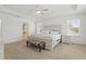 Bright main bedroom featuring a tray ceiling, ceiling fan, bench, and ensuite bathroom at 14838 Bahama Swallow Blvd, Winter Garden, FL 34787