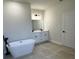 Bathroom showcasing a modern soaking tub, dual vanities with dark fixtures, and a well-lit mirror at 15750 Sw 40Th Ter Sw 40Th Ter, Ocala, FL 34473