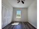 Bedroom featuring wood-look flooring, a ceiling fan, double door closet and a window overlooking the backyard at 15750 Sw 40Th Ter Sw 40Th Ter, Ocala, FL 34473