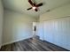 This bedroom features wood-look flooring, ceiling fan, and a double door closet with views of the rest of the house at 15750 Sw 40Th Ter Sw 40Th Ter, Ocala, FL 34473