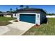 Charming single-story home featuring a modern design, blue garage door and well-manicured lawn at 15750 Sw 40Th Ter Sw 40Th Ter, Ocala, FL 34473