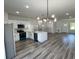 Open-concept kitchen with stainless steel appliances, modern lighting, and a quartz island, seamlessly connected to the living area at 15750 Sw 40Th Ter Sw 40Th Ter, Ocala, FL 34473