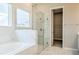 A walk-in glass shower enclosure and a separate soaking tub in bathroom at 16271 Silver Grove Blvd, Winter Garden, FL 34787