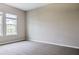 A carpeted bedroom with neutral walls and a window with a view of the community at 16271 Silver Grove Blvd, Winter Garden, FL 34787
