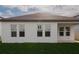 The back of the house with a grassy yard and many windows at 16271 Silver Grove Blvd, Winter Garden, FL 34787