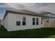 The back of the house with a grassy yard, many windows, and a covered porch at 16271 Silver Grove Blvd, Winter Garden, FL 34787