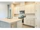 A modern kitchen with white cabinets, stainless steel appliances, and a large island at 16271 Silver Grove Blvd, Winter Garden, FL 34787
