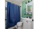 Bathroom with tile flooring, shower with blue curtain, white sink and green wall at 1635 Magnolia Ave, South Daytona, FL 32119