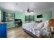 Spacious bedroom with green walls, ceiling fan, and desk setup with hardwood floors at 1635 Magnolia Ave, South Daytona, FL 32119