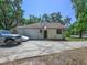 Home exterior with attached garage, a well-maintained lawn, and mature shade trees at 1635 Magnolia Ave, South Daytona, FL 32119