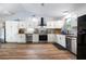 Bright kitchen featuring white cabinets, stainless steel appliances, and hardwood floors at 1635 Magnolia Ave, South Daytona, FL 32119
