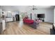 Open living room with light wood flooring, modern ceiling fan and kitchen in background at 1635 Magnolia Ave, South Daytona, FL 32119