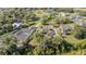 Aerial view of beautiful home with solar panels, screened in pool, mature trees and established landscaping at 1651 Big Oak Ln, Kissimmee, FL 34746