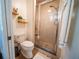 Compact bathroom with a tiled shower, toilet, and open shelving at 1651 Big Oak Ln, Kissimmee, FL 34746