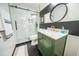 Stylish bathroom featuring a glass-enclosed shower, black hexagon tile floor, and green vanity cabinet with marble countertop at 1651 Big Oak Ln, Kissimmee, FL 34746