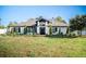 Charming single-story home featuring a manicured front yard, classic design, and black trim windows at 1651 Big Oak Ln, Kissimmee, FL 34746