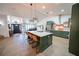 Stunning kitchen with a large island, green cabinets, stainless steel appliances, and modern pendant lights at 1651 Big Oak Ln, Kissimmee, FL 34746