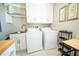 Practical laundry room includes washer, dryer, utility sink, ample cabinet storage and wood look flooring at 1651 Big Oak Ln, Kissimmee, FL 34746