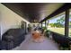 Enclosed patio featuring a dining area and outdoor grill overlooking the backyard at 1651 Big Oak Ln, Kissimmee, FL 34746