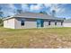 Back of house features a sliding door, several windows, and a spacious green lawn at 16771 Sw 21St Terrace Rd, Ocala, FL 34473