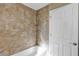 Bright bathroom featuring tiled walls, a soaking tub, and a white door at 16771 Sw 21St Terrace Rd, Ocala, FL 34473