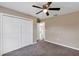 Bedroom with neutral walls, carpet, a ceiling fan, a closet, and an open door at 16771 Sw 21St Terrace Rd, Ocala, FL 34473