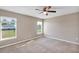 Bedroom with neutral walls, carpet, a ceiling fan, and windows overlooking the yard at 16771 Sw 21St Terrace Rd, Ocala, FL 34473