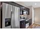 Close-up of the kitchen with stainless steel refrigerator, dark cabinets, microwave, and range with granite countertops at 16771 Sw 21St Terrace Rd, Ocala, FL 34473