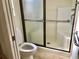 Bathroom featuring a toilet, shower with sliding glass doors and a safety grab bar at 1805 San Luis Ln, The Villages, FL 32159