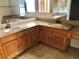 Bathroom with double sinks, granite counters, wood cabinets, and a large vanity mirror at 1805 San Luis Ln, The Villages, FL 32159