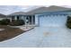 Inviting single-story home with a two-car garage and a beautifully painted driveway at 1805 San Luis Ln, The Villages, FL 32159